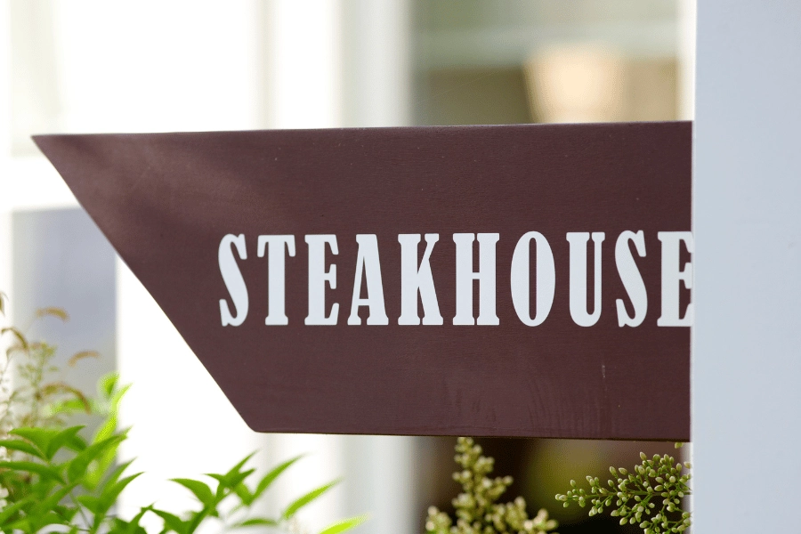 brown sign outside of a restaurant that says steakhouse